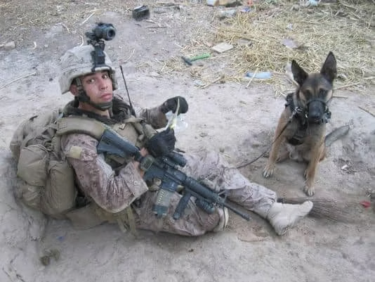 A deployed service member in the field with combat gear