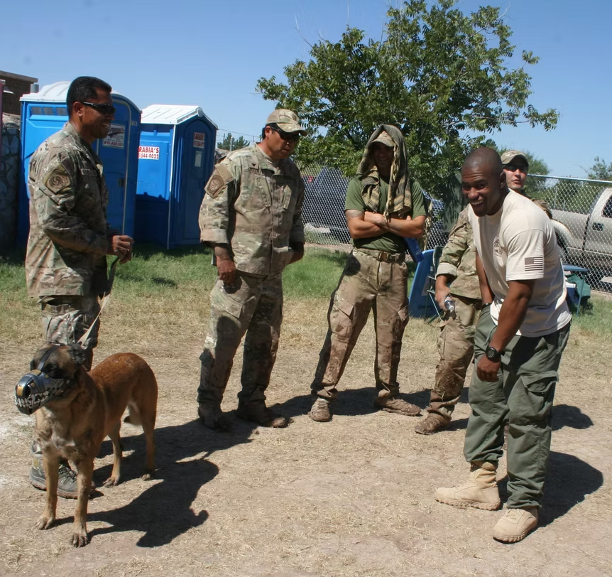 Service members and their working dogs at an outdoor gathering